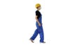 Young woman in hard hat and medical mask walking on white backgr Royalty Free Stock Photo