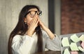 Young woman hard working, taking off glasses