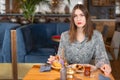 A young woman has Breakfast in a cafe. Oatmeal with salted caramel and prunes, in the original serving. Breakfast