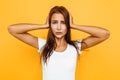 Young woman has headache, on yellow background Royalty Free Stock Photo