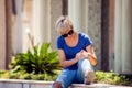 Young woman has knee pain during outdoor walking. Healthcare, medicine, people concept Royalty Free Stock Photo