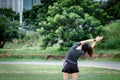 Young woman has an outdoor workout at the park. She is stretching her arms and looking away. Health care Royalty Free Stock Photo