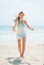 Young woman in hat and with bag having fun time on beach Royalty Free Stock Photo