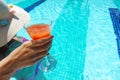 Young woman with hat and colorful swimsuit drinking cocktail at swimming pool Royalty Free Stock Photo