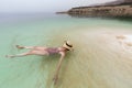 Young woman with hat floating in the waters of the Dead Sea Royalty Free Stock Photo