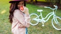 Young woman in hat holding red apple in her hand with bicycle Royalty Free Stock Photo