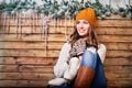 Woman in a hat and mittens sitting on the bench with skates Royalty Free Stock Photo