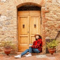 young woman with hat posing near wooden door in old italian tuscany town Royalty Free Stock Photo