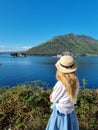 Young woman in hat stands on the coastline in Montenegro Saint George Island in Kotor Bay Boka Kotorska near Perast city