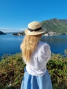 Young woman in hat stands on the coastline in Montenegro Saint George Island in Kotor Bay Boka Kotorska