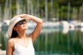 Young woman with hat summer dress and sunglasses walks pier of m