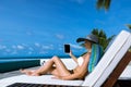 Young woman in hat with tablet pc at the beach Royalty Free Stock Photo