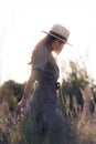 Young woman in hat walks among lavender field Royalty Free Stock Photo