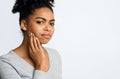 Young woman having acute teeth pain, touching her cheek