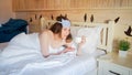 Portrait of young woman having coffee in bed at morning Royalty Free Stock Photo