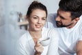 Young woman having coffee with boyfriend in bed Royalty Free Stock Photo