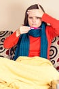 Young woman having flu and checking a thermometer Royalty Free Stock Photo