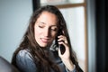 Young woman having a fun conversation over phone at home Royalty Free Stock Photo