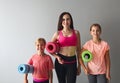 Young woman having fun with kids doing yoga