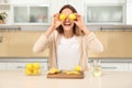 Young woman having fun while making lemon water