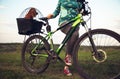 Young woman having fun near countryside park, riding bike, traveling with companion spaniel dog Royalty Free Stock Photo