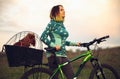 Young woman having fun near countryside park, riding bike, traveling with companion spaniel dog Royalty Free Stock Photo