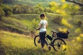 Young woman having fun near countryside park, riding bike, traveling at spring day Royalty Free Stock Photo