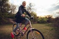 Young woman having fun near countryside park, riding bike, traveling at spring day Royalty Free Stock Photo