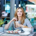 Young woman having healthy breakfast in outdoor cafe Royalty Free Stock Photo