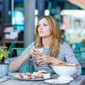 Young woman having healthy breakfast in outdoor cafe Royalty Free Stock Photo