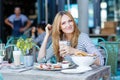 Young woman having healthy breakfast in outdoor cafe Royalty Free Stock Photo