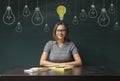 Young woman having idea over blackboard background