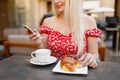 Young woman having italian breakfast with croissant and coffee a