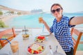 Young woman having lunch with delicious fresh greek salad, frappe and brusketa served for lunch at outdoor restaurant Royalty Free Stock Photo