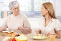 Young woman having lunch with mother smiling Royalty Free Stock Photo