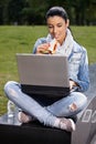 Young woman having lunch in park using laptop Royalty Free Stock Photo