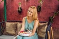 Young woman having a mediterranean breakfast seated at her sofa and with her cat and eats Healthy tropical breakfast Royalty Free Stock Photo