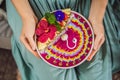 Young woman having a mediterranean breakfast seated at her sofa and eats Healthy tropical breakfast, smoothie bowl with Royalty Free Stock Photo