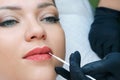 Young woman having permanent makeup on her lips at the beautician salon Royalty Free Stock Photo