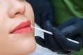 Young woman having permanent makeup on her lips at the beautician salon Royalty Free Stock Photo