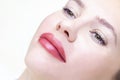 Young woman having permanent makeup on her lips in a cosmetologists salon. Royalty Free Stock Photo