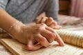 Young woman having rheumatoid is reading a book. Hands and legs are deformed. She feels pain. Selective focus