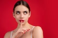 Young woman having secret while holding finger on lips and showing silence sign. Shh sign. Beautiful woman with silent Royalty Free Stock Photo