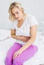 Young woman having stomach pain in bed Royalty Free Stock Photo