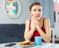 Woman having toothache, sitting at table at home Royalty Free Stock Photo