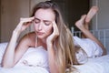 Young woman with headache on bed closeup