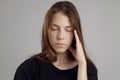 A young woman with a headache, holding her head, isolated on a white background. Portrait of a girl, medical theme, pain Royalty Free Stock Photo