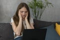 Young woman with headache is trying to concentrate at work. Migraine headaches during working day