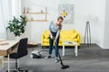 Woman in headphones cleaning carpet with