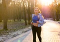 Young woman in headphones enjoys jogging in park Royalty Free Stock Photo